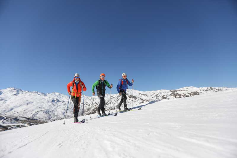 Trois skieurs sur une montagne enneigée 